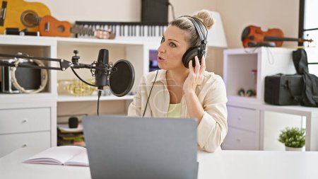 Téléchargez les photos : Jeune journaliste blonde parlant à la radio au studio de radio - en image libre de droit