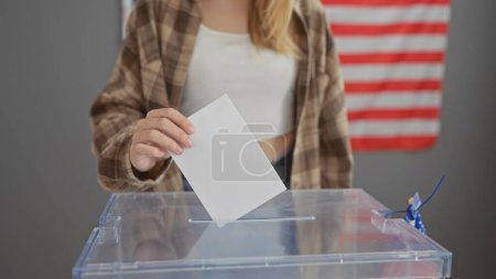 Eine junge blonde Frau gibt ihre Stimme in einem Wahllokal des Wahlkollegiums ab und verkörpert Demokratie und Bürgerpflicht.