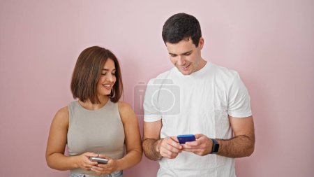 Photo for Beautiful couple smiling confident using smartphones over isolated pink background - Royalty Free Image