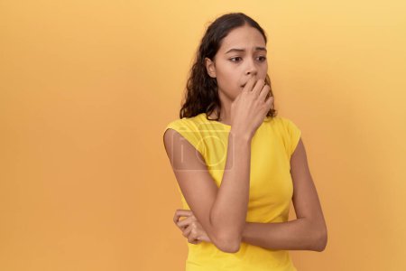 Téléchargez les photos : Jeune femme afro-américaine debout avec une expression nerveuse sur fond jaune isolé - en image libre de droit