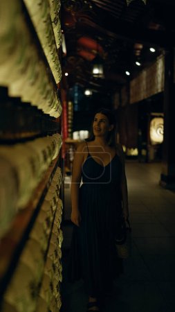 Téléchargez les photos : Belle jeune femme hispanique regardant lanterne asiatique au temple japonais à Tokyo la nuit - en image libre de droit