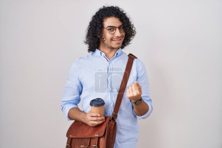 Photo for Hispanic man with curly hair drinking a cup of take away coffee beckoning come here gesture with hand inviting welcoming happy and smiling - Royalty Free Image