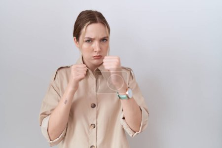 Photo for Young caucasian woman wearing casual shirt ready to fight with fist defense gesture, angry and upset face, afraid of problem - Royalty Free Image