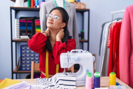 Photo for Young chinese woman tailor stressed using sewing machine at atelier - Royalty Free Image