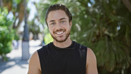 Téléchargez les photos : Jeune homme hispanique souriant confiant debout au parc - en image libre de droit