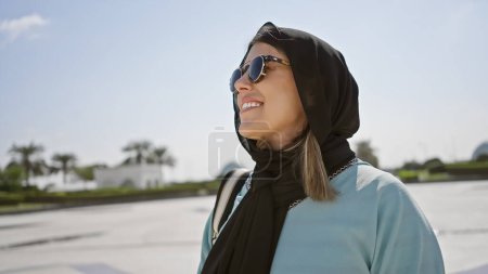 Photo for A smiling young adult hispanic woman wearing a hijab at an islamic mosque in abu dhabi, uae. - Royalty Free Image