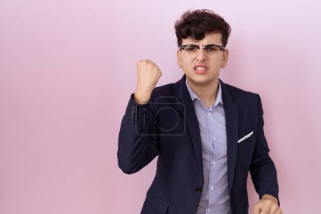 Photo for Young non binary man with beard wearing suit and tie angry and mad raising fist frustrated and furious while shouting with anger. rage and aggressive concept. - Royalty Free Image