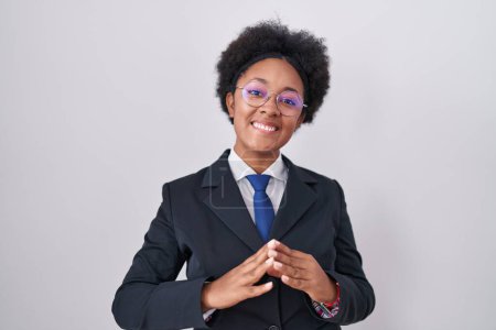 Téléchargez les photos : Belle femme africaine aux cheveux bouclés portant veste d'affaires et lunettes mains ensemble et doigts croisés souriant détendu et joyeux. succès et optimisme - en image libre de droit