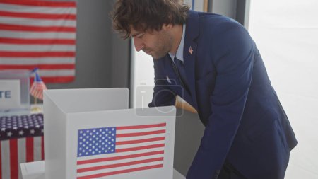 Foto de Hombre hispano votando en un escenario electoral americano con un fondo de bandera. - Imagen libre de derechos