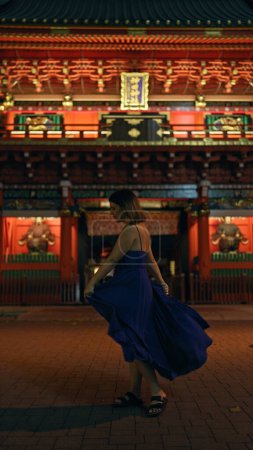 Téléchargez les photos : Nuit enchanteresse à Tokyo, belle femme hispanique capturée tournant autour d'une robe dans un temple japonais traditionnel - en image libre de droit