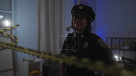 Smiling woman officer in uniform standing by crime scene tape in a dimly lit indoor space