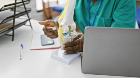 Téléchargez les photos : Physiothérapeute afro-américaine expliquant un modèle de genou dans une clinique de désintox - en image libre de droit
