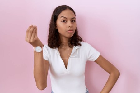 Téléchargez les photos : Jeune femme hispanique portant un t-shirt blanc décontracté faisant geste italien avec expression confiante main et doigts - en image libre de droit