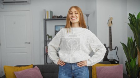 Photo for A smiling young redhead woman in a cozy living room, exuding casual elegance and comfort. - Royalty Free Image