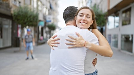 Téléchargez les photos : Père et fille confiants partagent un câlin joyeux et intime, debout dans une rue de la ville, émanant l'amour et le bonheur avec leurs sourires ensoleillés. - en image libre de droit