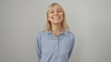 Photo for A smiling caucasian woman with blonde hair in a blue shirt against a white background portrays approachability and confidence. - Royalty Free Image