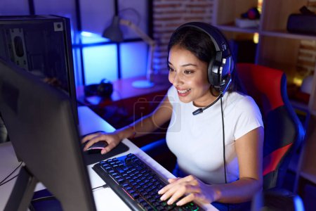 Téléchargez les photos : Young arab woman streamer playing video game using computer at gaming room - en image libre de droit