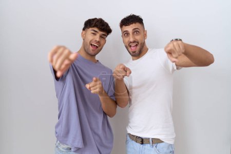 Photo for Homosexual gay couple standing over white background pointing to you and the camera with fingers, smiling positive and cheerful - Royalty Free Image