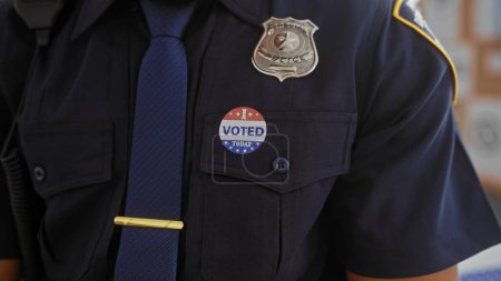 Téléchargez les photos : Gros plan d'un policier américain avec un autocollant "voté" symbolisant le devoir civique et la participation des forces de l'ordre à la démocratie. - en image libre de droit