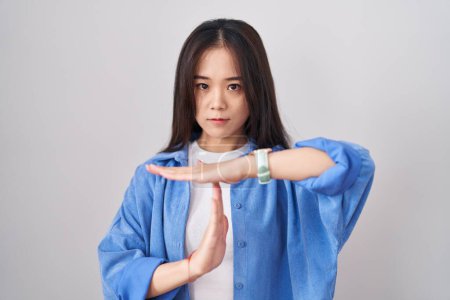 Téléchargez les photos : Jeune femme chinoise debout sur fond blanc faisant un geste avec les mains, frustré et sérieux visage - en image libre de droit