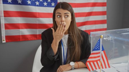 Überraschte junge hispanische Frau mit amerikanischer Flagge im Hintergrund am Electoral College