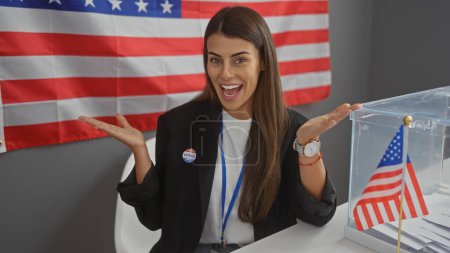 Foto de Mujer hispana sonriendo cerca de bandera americana en colegio electoral vistiendo etiqueta 'voté'. - Imagen libre de derechos