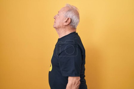 Photo for Senior man with grey hair wearing bitcoin t shirt looking to side, relax profile pose with natural face and confident smile. - Royalty Free Image