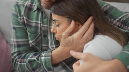 Photo for Affectionate couple embracing tenderly on a cozy sofa indoors, with the man comforting the woman in a supportive environment. - Royalty Free Image