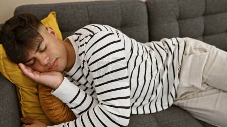 Attraktiver, junger hispanischer Mann fand bequeme Entspannung, schlafend auf dem gemütlichen Sofa, müde und erschöpft, im gemütlichen Ambiente seines heimischen Wohnzimmers liegend, einfach nur entspannen.