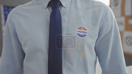 Téléchargez les photos : Gros plan d'un homme portant un autocollant "voté" à égalité, représentant le devoir civique américain dans un centre électoral. - en image libre de droit