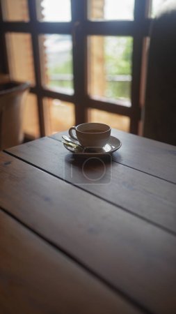 Photo for A cozy cup of tea on a wooden table by a window with garden views, invoking a sense of calm and relaxation - Royalty Free Image