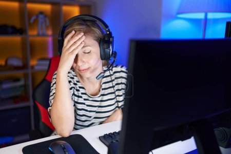 Foto de Joven mujer rubia streamer estresado utilizando la computadora en la sala de juegos - Imagen libre de derechos