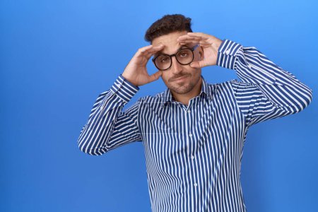 Photo for Hispanic man with beard wearing glasses trying to open eyes with fingers, sleepy and tired for morning fatigue - Royalty Free Image