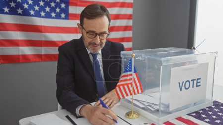 Téléchargez les photos : Homme d'âge moyen avec une barbe votant dans un centre électoral américain, mettant en valeur le patriotisme et la démocratie. - en image libre de droit