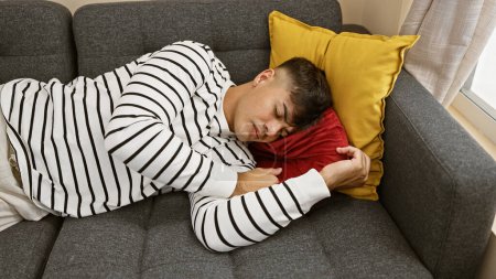 attrayant, jeune homme hispanique trouvé détente confortable, dormir profondément sur le canapé confortable, fatigué et épuisé, couché dans l'ambiance confortable de sa maison intérieure salon, tout simplement se détendre.