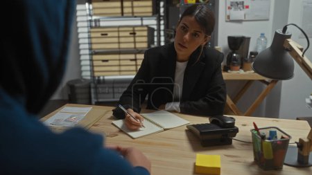 A woman investigator meticulously takes notes in an office during an interrogation, suggesting a suspenseful crime scene.