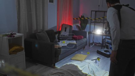 A man investigates a simulated indoor crime scene in a dimly lit, domestic setting with evidence markers.