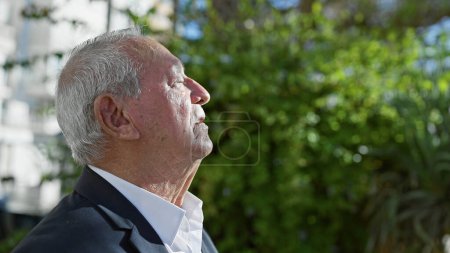 Foto de Hombre mayor respirando con los ojos cerrados en el parque - Imagen libre de derechos