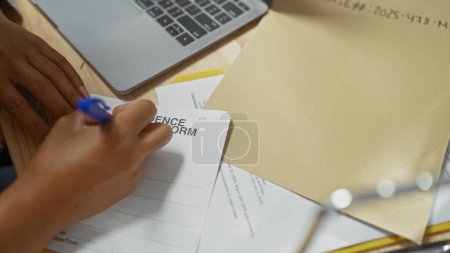 Close-up of a woman's hands labeling an evidence form beside a laptop at a police station.