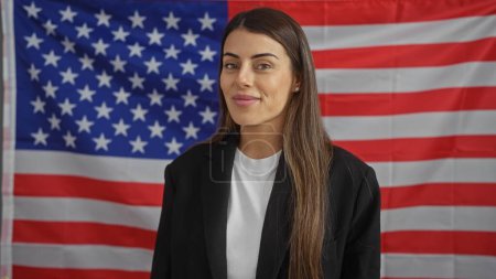 Portrait of a confident young hispanic woman in formal attire before an american flag