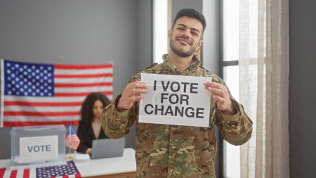 A smiling man in military uniform holds a 'vote for change' sign in a room with an american flag and a woman at a table with a 'vote' sign.
