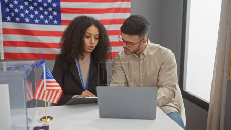 Homme et femme discutant dans une pièce avec un drapeau US, incarnant un cadre de gouvernement professionnel au sein des États-Unis.