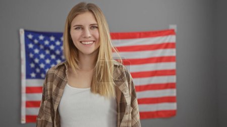 Photo for Smiling young woman in casual wear with american flag background in a modern office setting - Royalty Free Image