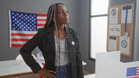 Afroamerikanerin mit Zöpfen an einem indoor United States Electory College, mit amerikanischer Flagge.