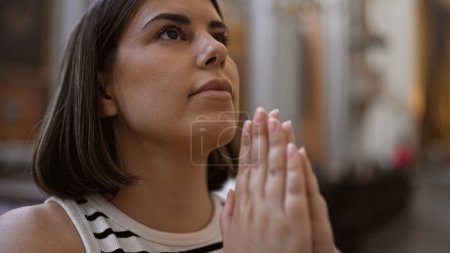 Foto de Joven mujer hispana hermosa rezando en la iglesia agustiniana de Viena - Imagen libre de derechos