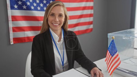Eine lächelnde Frau mit einem Abzeichen steht an einer Wahlurne in einem Raum mit der amerikanischen Flagge, die Demokratie und Bürgerpflicht symbolisiert..