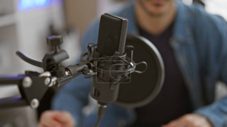 Enregistrement homme focalisé avec microphone à condensateur en studio intérieur.