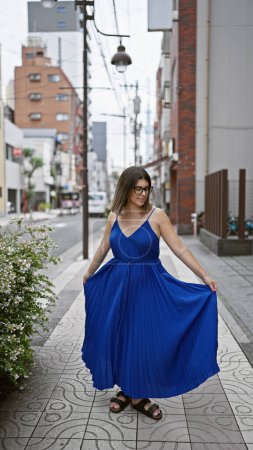 Fröhliche hispanische Frau beim Tanzen, Brille glitzernd, während sie ihr Kleid auf den belebten Tokyostraßen dreht, verkörpert urbanen Stil und weibliche Freiheit