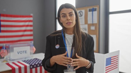 Téléchargez les photos : Femme hispanique au bureau de vote américain avec insigne de vote et drapeau - en image libre de droit