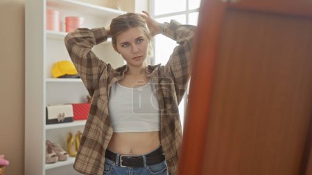 Foto de Una joven rubia con un atuendo casual posa en un armario moderno, reflejando un sentido de la moda y el estilo de vida. - Imagen libre de derechos